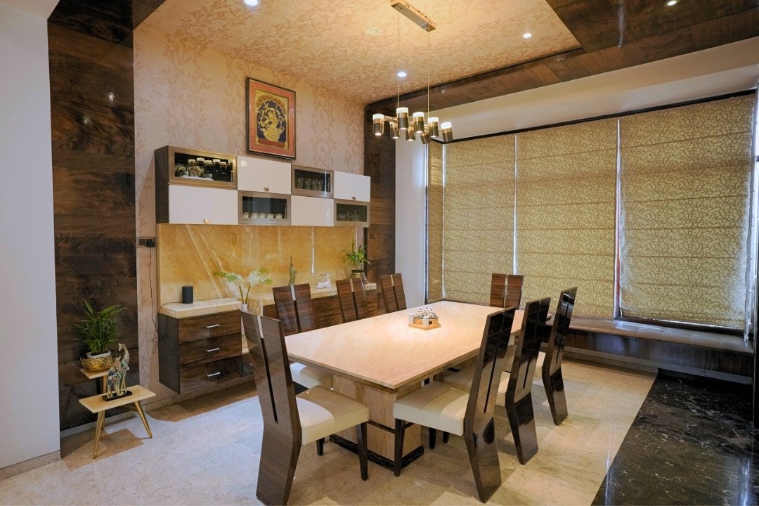 Dining room with pendant chandelier and crockery unit by HOH Luxe