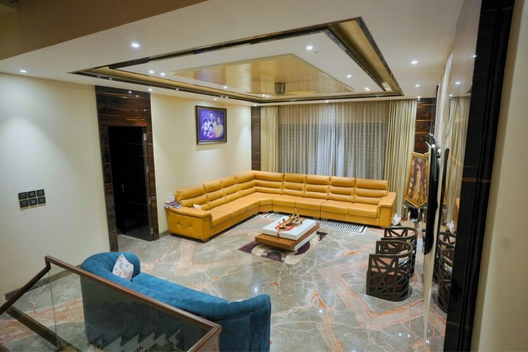 Family lounge with sectional sofa and marble flooring by HOH Luxe