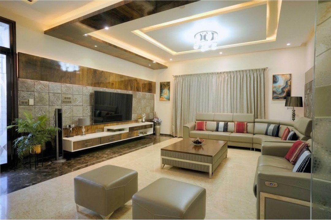 Living room with TV wall and sectional sofa by HOH Luxe